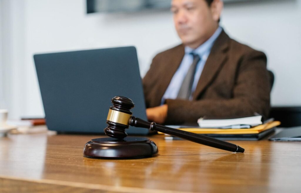 Mostoles Asesores Madrid Crop concentrated Asian male judge in formal clothes sitting using modern netbook while working in law office