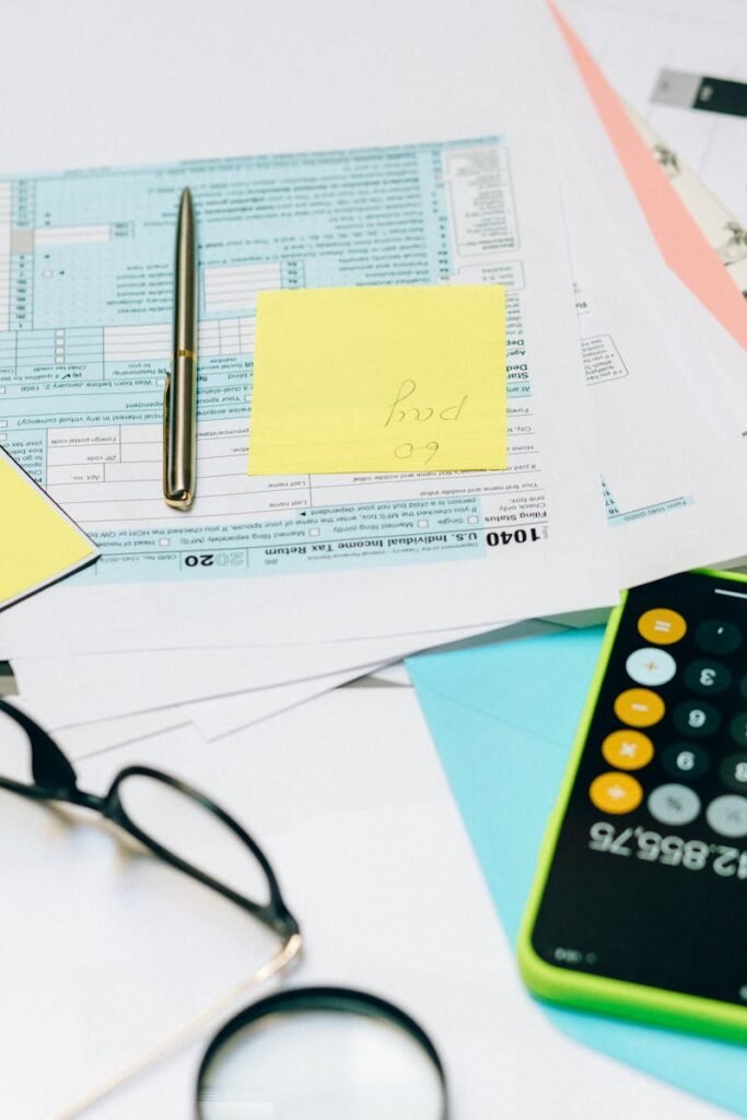 Contactar con Mostoles Asesores Close-up of tax documents with a calculator, pen, and notes, ideal for financial content.